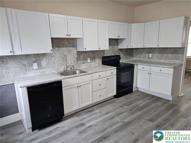 142 Front St, Catasauqua Boro, PA 18032 - kitchen with black appliances, white cabinetry, light countertops, tasteful backsplash, and light wood finished floors