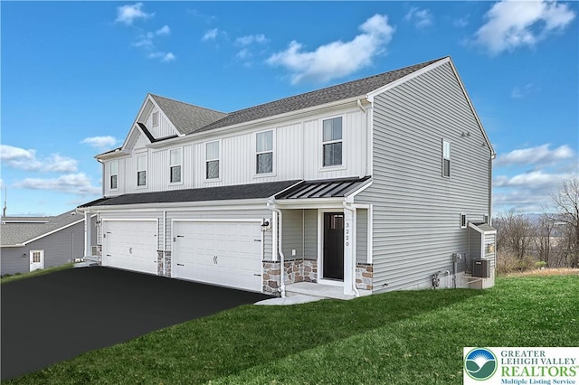 3220 Eisenhower Dr, Allen Twp, PA 18067 - view of front facade with an attached garage, a front yard, a standing seam roof, asphalt driveway, and stone siding
