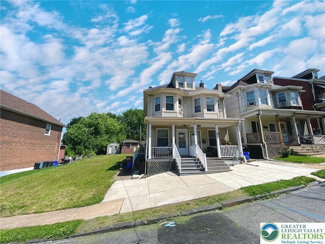 1139 Jackson St, Easton, PA 18042 - view of front facade featuring a porch, a front lawn, and a shed