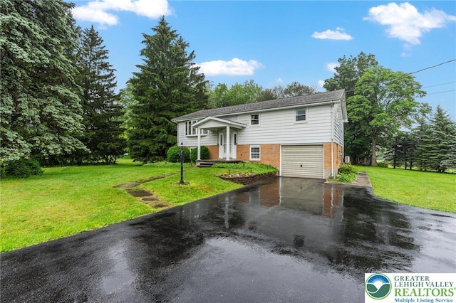 2560 Community Dr, Moore Twp, PA 18014 - raised ranch featuring asphalt driveway, an attached garage, a front yard, and brick siding
