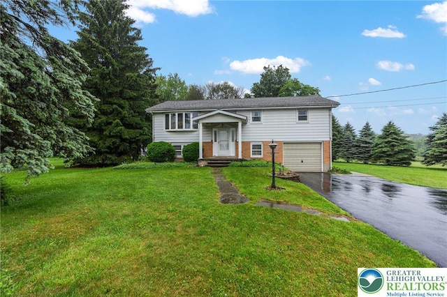 2560 Community Dr, Moore Twp, PA 18014 - raised ranch featuring driveway, brick siding, a front lawn, and a garage