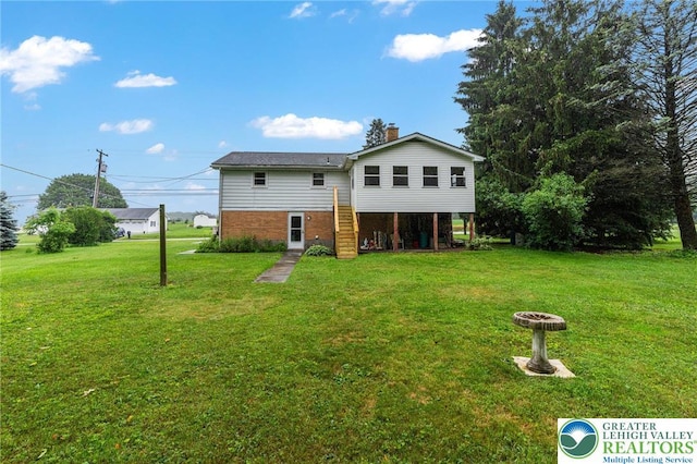 2560 Community Dr, Moore Twp, PA 18014 - rear view of property featuring brick siding, a yard, stairs, and a chimney