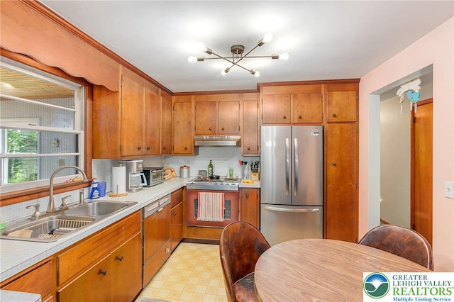 2560 Community Dr, Moore Twp, PA 18014 - kitchen with freestanding refrigerator, under cabinet range hood, dishwasher, light countertops, and a chandelier