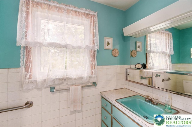 2560 Community Dr, Moore Twp, PA 18014 - bathroom featuring vanity, wainscoting, and tile walls