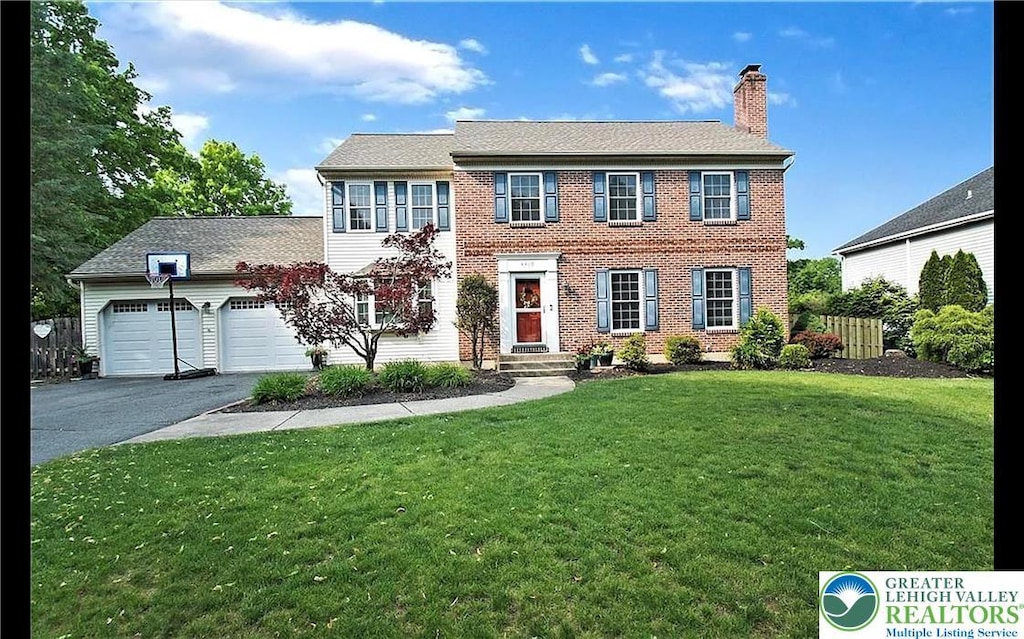 4410 Greenfield Rd, Hanover Twp, PA 18017 - colonial home with asphalt driveway, a chimney, an attached garage, a front lawn, and brick siding