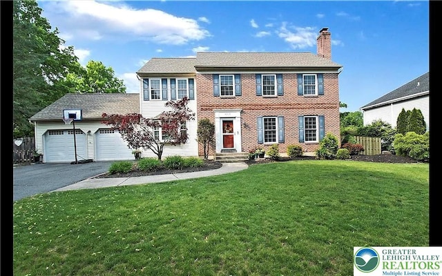 4410 Greenfield Rd, Hanover Twp, PA 18017 - colonial home with asphalt driveway, a chimney, an attached garage, a front lawn, and brick siding