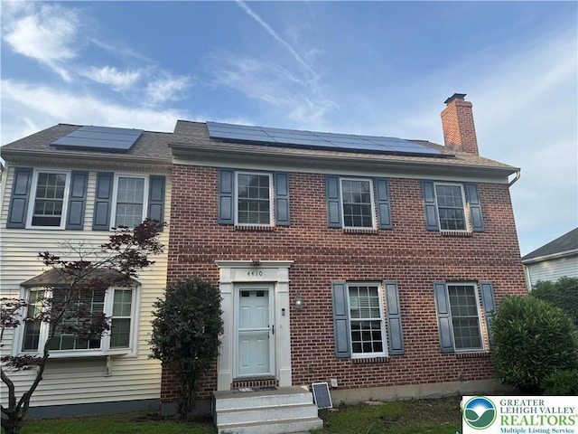 4410 Greenfield Rd, Hanover Twp, PA 18017 - view of front facade with a chimney, brick siding, and roof mounted solar panels