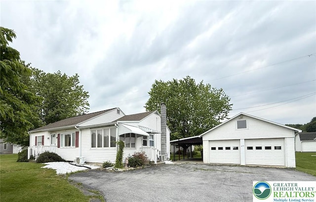 619 Penn Dr, West Penn Twp, PA 18252 - ranch-style house featuring a chimney, a detached garage, a front yard, an outdoor structure, and asphalt driveway