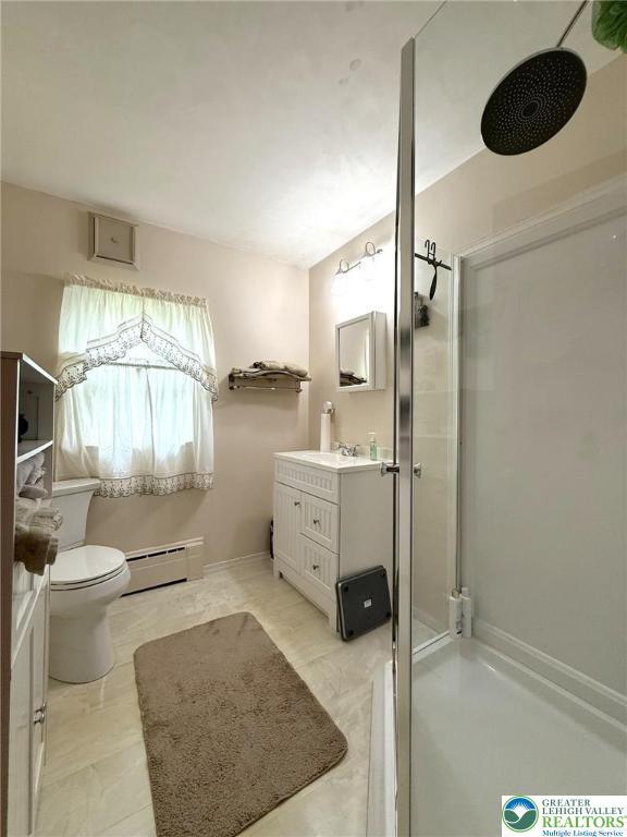 619 Penn Dr, West Penn Twp, PA 18252 - bathroom featuring a baseboard heating unit, vanity, and a shower stall