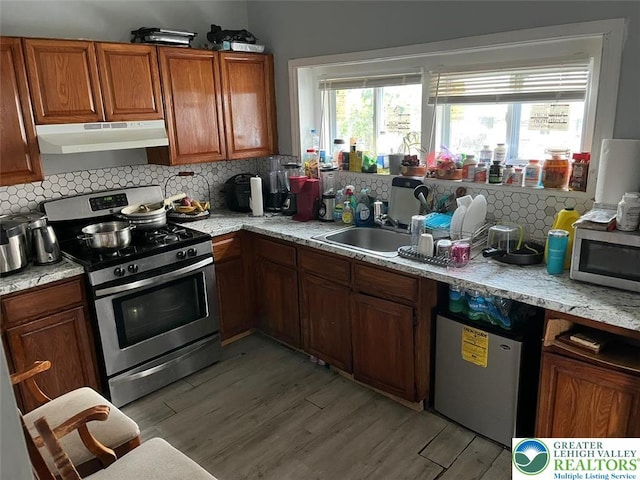 103 N Oak St, Easton, PA 18042 - kitchen featuring appliances with stainless steel finishes, under cabinet range hood, plenty of natural light, and decorative backsplash