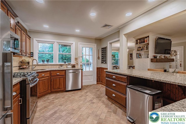 326 N Main St, Allentown City, PA 18104 - kitchen with appliances with stainless steel finishes, ornamental molding, light stone countertops, wainscoting, and brown cabinets