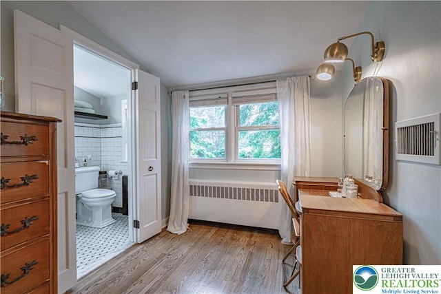 326 N Main St, Allentown City, PA 18104 - bathroom featuring radiator, wood finished floors, tile walls, and vaulted ceiling