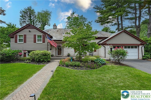 326 N Main St, Allentown City, PA 18104 - split level home featuring a garage, a front yard, asphalt driveway, a chimney, and brick siding
