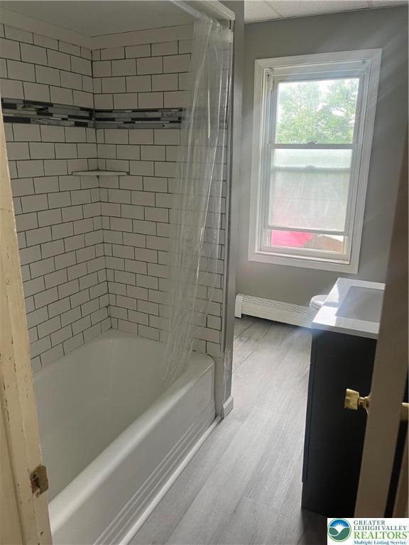 827 Louis St, Easton, PA 18042 - bathroom with a baseboard radiator, vanity, wood finished floors, and  shower combination