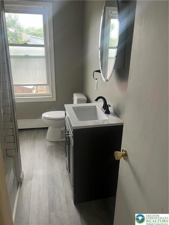 827 Louis St, Easton, PA 18042 - bathroom with vanity, wood finished floors, a baseboard radiator, and healthy amount of natural light