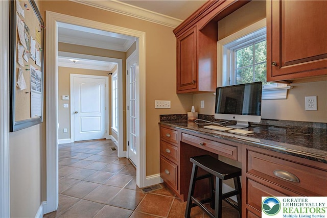 3054 Jordan Rd, North Whitehall Twp, PA 18069 - kitchen featuring brown cabinets, crown molding, dark stone counters, tile patterned flooring, and a desk