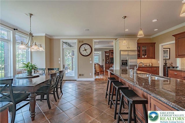 3054 Jordan Rd, North Whitehall Twp, PA 18069 - kitchen featuring stainless steel fridge with ice dispenser, plenty of natural light, a kitchen breakfast bar, dark stone countertops, and ornamental molding