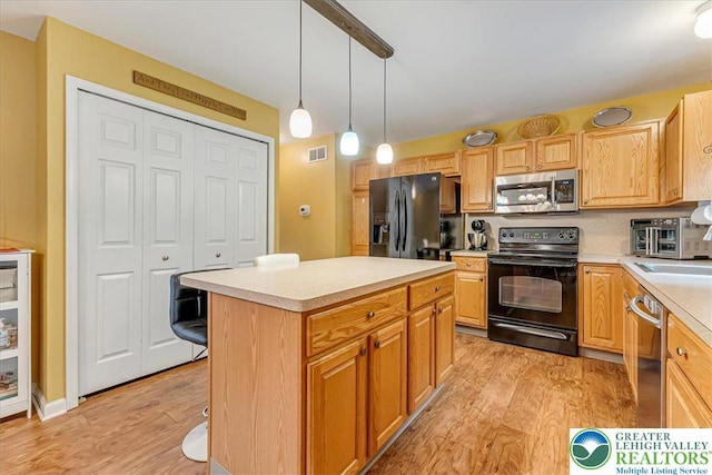 617 Lehigh Gap St, Walnutport Boro, PA 18088 - kitchen with black appliances, light wood-style floors, light countertops, and a kitchen island