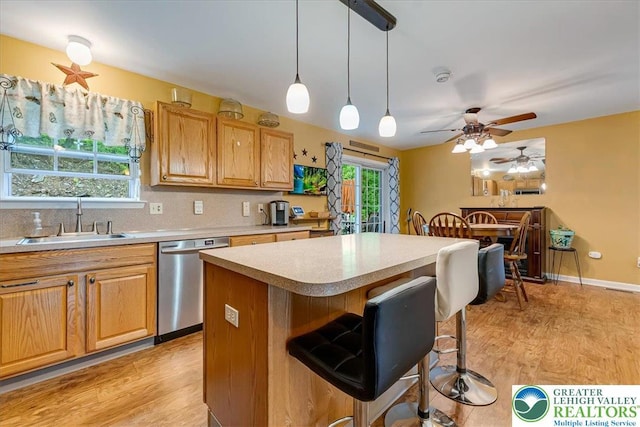 617 Lehigh Gap St, Walnutport Boro, PA 18088 - kitchen featuring stainless steel dishwasher, light countertops, light wood-style flooring, and a kitchen bar