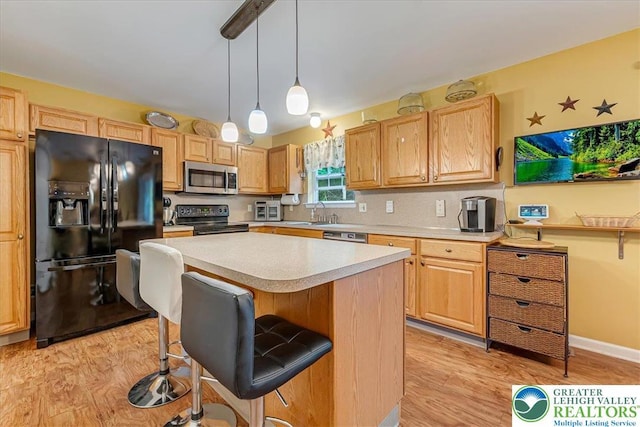 617 Lehigh Gap St, Walnutport Boro, PA 18088 - kitchen featuring black appliances, light countertops, a kitchen island, light wood-style floors, and a kitchen bar