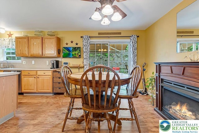 617 Lehigh Gap St, Walnutport Boro, PA 18088 - dining space featuring light wood-type flooring, healthy amount of natural light, a ceiling fan, and a glass covered fireplace