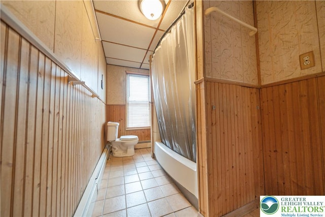 20 N 3rd St, Coplay Boro, PA 18037 - full bathroom featuring a wainscoted wall, wooden walls, a baseboard heating unit, shower / bath combo with shower curtain, and tile patterned floors