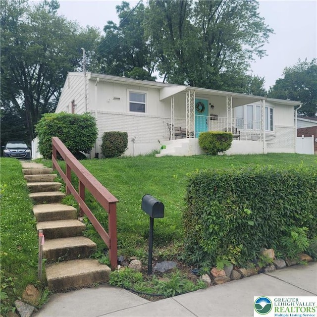 942 S Front St, Allentown City, PA 18103 - view of front facade featuring brick siding, a porch, and a front lawn