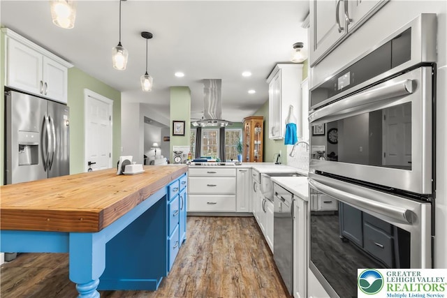 1661 Marjorie Ct, Middle Smithfield Twp, PA 18302 - kitchen with wood counters, appliances with stainless steel finishes, island range hood, white cabinetry, and wood finished floors