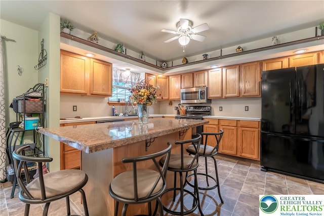 3195 Audubon St, Palmer Twp, PA 18045 - kitchen with freestanding refrigerator, stainless steel microwave, a breakfast bar area, a ceiling fan, and a center island