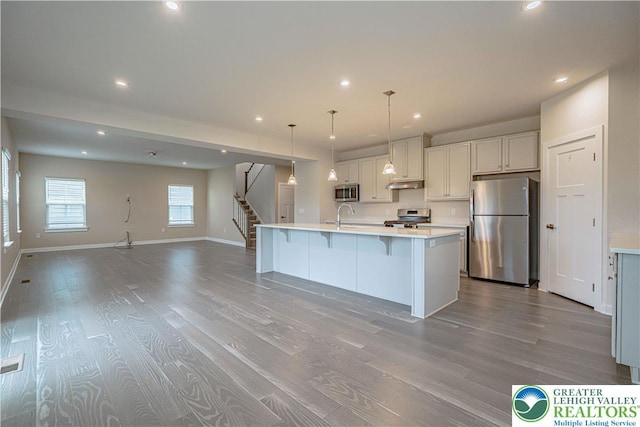 3610 Sweet Meadow Ct, Macungie Boro, PA 18062 - kitchen featuring appliances with stainless steel finishes, light countertops, recessed lighting, wood finished floors, and a breakfast bar area