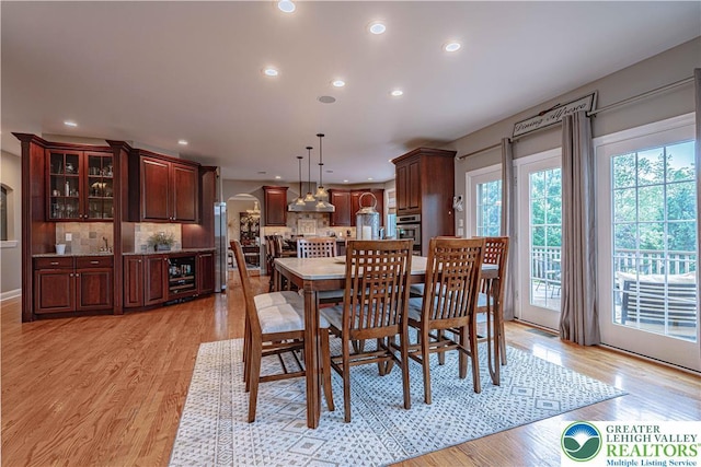 6532 Forest Knoll Ct, Upper Macungie Twp, PA 18106 - dining space featuring wine cooler, arched walkways, light wood-style floors, and recessed lighting