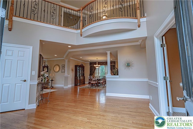 6532 Forest Knoll Ct, Upper Macungie Twp, PA 18106 - entrance foyer with decorative columns, a towering ceiling, wood finished floors, a chandelier, and crown molding