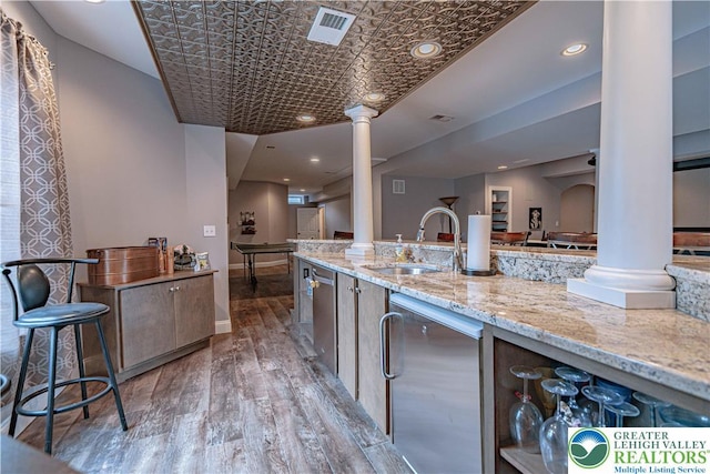 6532 Forest Knoll Ct, Upper Macungie Twp, PA 18106 - kitchen featuring decorative columns, stainless steel dishwasher, wood finished floors, light stone counters, and recessed lighting