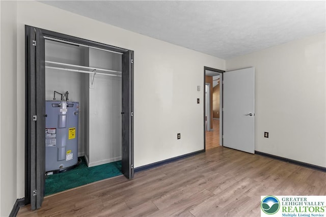197 Broad Mountain View Dr, Penn Forest Twp, PA 18229 - unfurnished bedroom featuring water heater, wood finished floors, and a closet