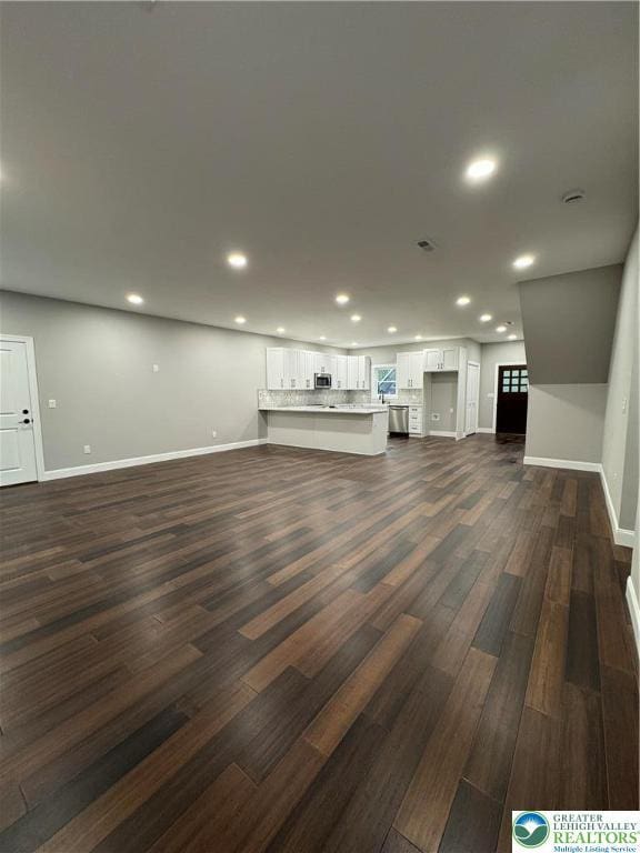 211 Maxatawny Dr, Coolbaugh Twp, PA 18347 - unfurnished living room with dark wood finished floors and recessed lighting