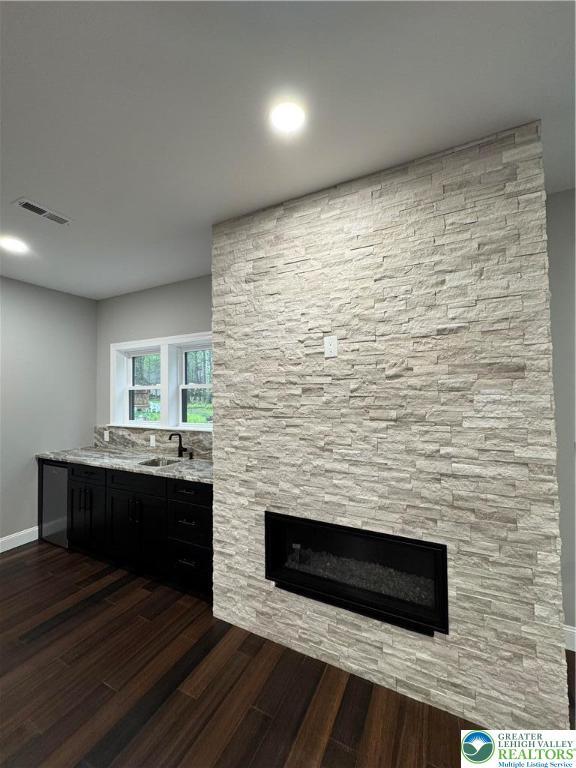211 Maxatawny Dr, Coolbaugh Twp, PA 18347 - bar with a stone fireplace and dark wood-style flooring