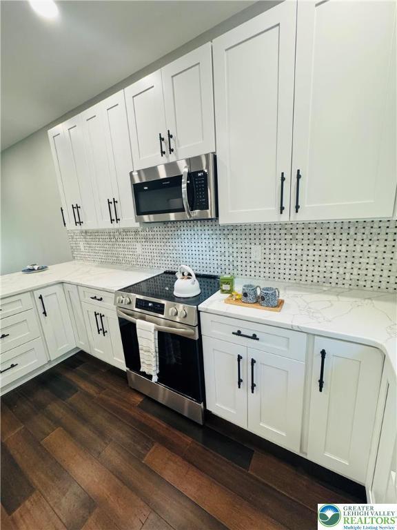 211 Maxatawny Dr, Coolbaugh Twp, PA 18347 - kitchen with appliances with stainless steel finishes, light stone countertops, dark wood-type flooring, and tasteful backsplash