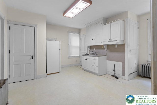 170 S Whitfield St, Nazareth Boro, PA 18064 - kitchen with freestanding refrigerator, radiator heating unit, white cabinets, and under cabinet range hood