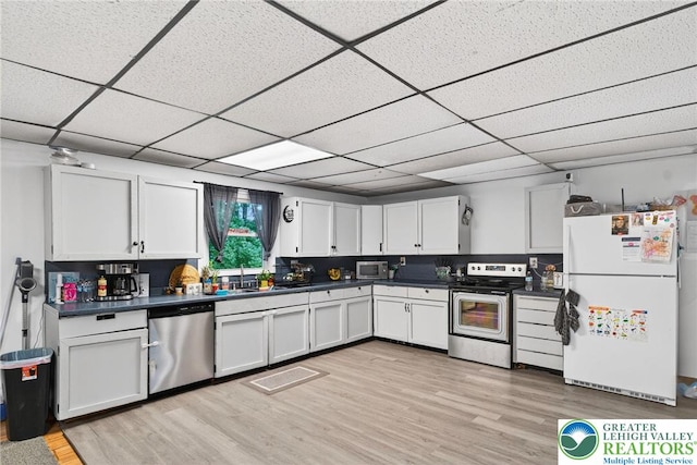 485 S Walnut St, Slatington Boro, PA 18080 - kitchen featuring appliances with stainless steel finishes, dark countertops, white cabinetry, light wood-style flooring, and a paneled ceiling