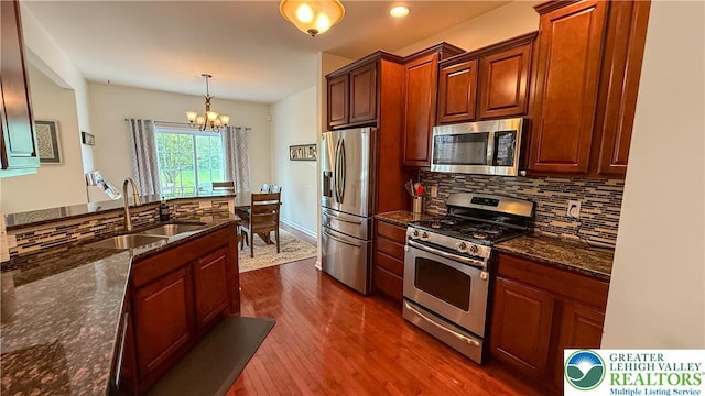 102 Gray Dr, Allen Twp, PA 18067 - kitchen with stainless steel appliances, a chandelier, backsplash, dark wood-style floors, and dark stone countertops