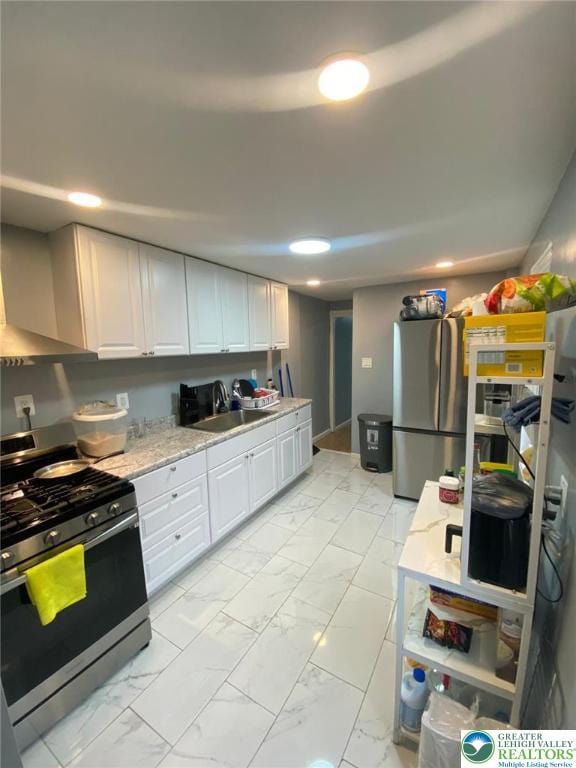 522 N Jordan St, Allentown City, PA 18102 - kitchen featuring appliances with stainless steel finishes, light marble finish floors, white cabinetry, recessed lighting, and light stone counters