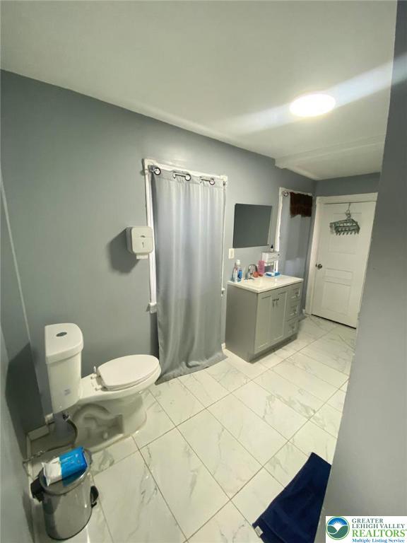 522 N Jordan St, Allentown City, PA 18102 - full bath with marble finish floors, vanity, and a shower with shower curtain