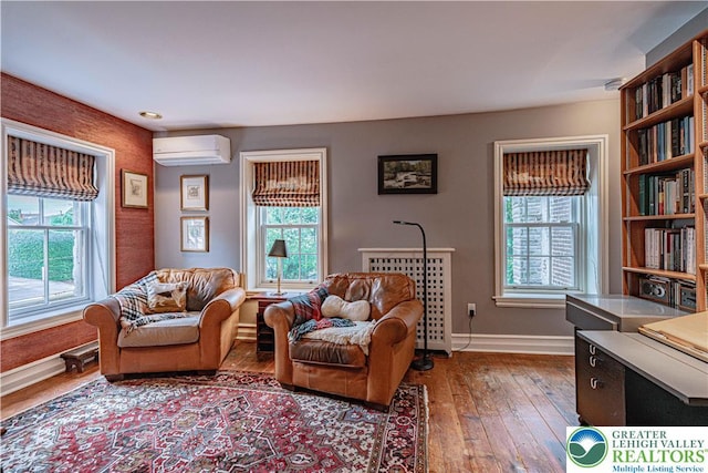 407 N 8th St, Allentown City, PA 18102 - living area featuring a wall unit AC, plenty of natural light, and wood-type flooring
