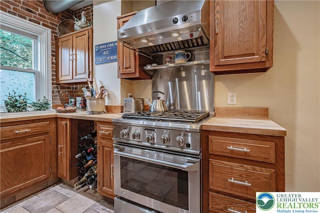407 N 8th St, Allentown City, PA 18102 - kitchen featuring high end stainless steel range, wall chimney range hood, brown cabinetry, and butcher block counters