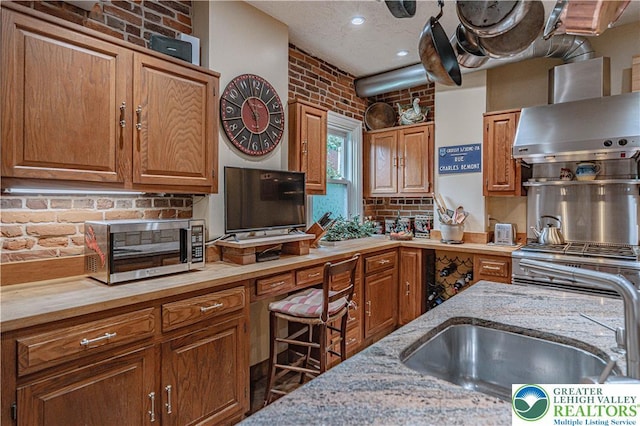 407 N 8th St, Allentown City, PA 18102 - kitchen with stainless steel microwave, wall chimney range hood, brown cabinetry, and recessed lighting