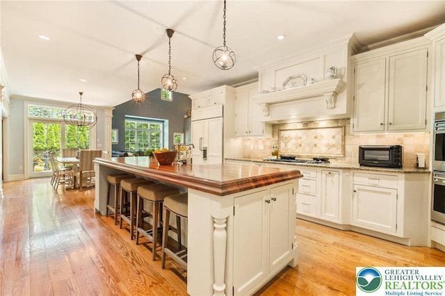 2051 Forge Run, Bethlehem City, PA 18015 - kitchen with paneled refrigerator, tasteful backsplash, gas stovetop, a center island with sink, and wooden counters
