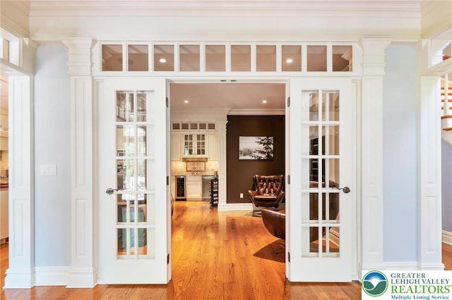 2051 Forge Run, Bethlehem City, PA 18015 - corridor with crown molding, light wood-style floors, wine cooler, and decorative columns