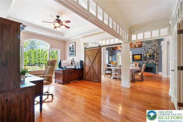 2051 Forge Run, Bethlehem City, PA 18015 - home office featuring a barn door, light wood-style flooring, ceiling fan, a stone fireplace, and crown molding