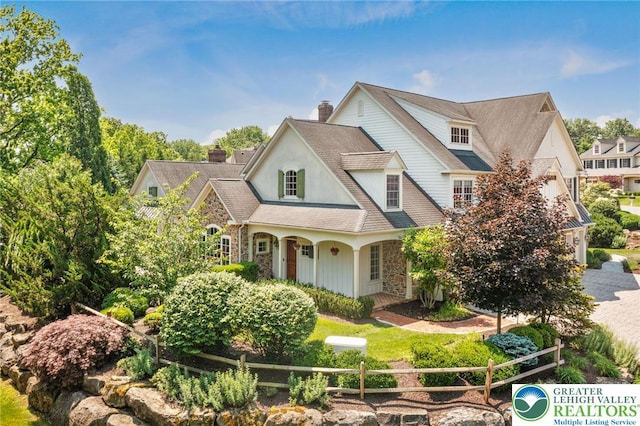 2051 Forge Run, Bethlehem City, PA 18015 - view of front of home featuring stone siding, a chimney, roof with shingles, stucco siding, and covered porch