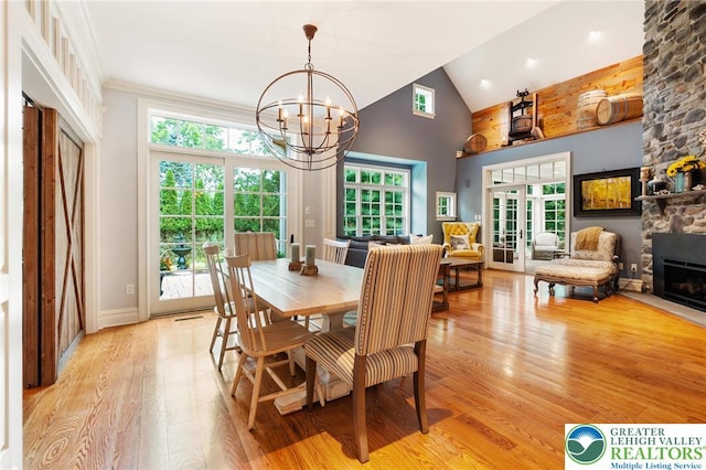 2051 Forge Run, Bethlehem City, PA 18015 - dining room with light wood-style flooring, a chandelier, plenty of natural light, a stone fireplace, and high vaulted ceiling